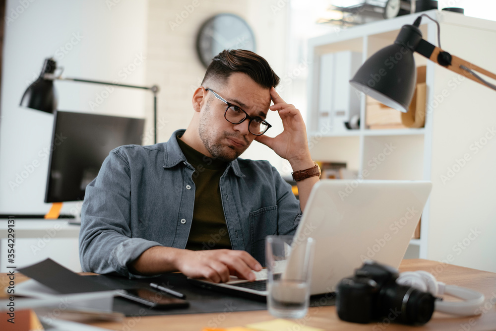 Young businessman using laptop in his office. Handsome man working in office. Young businessman using laptop in his office. Handsome man working in office.