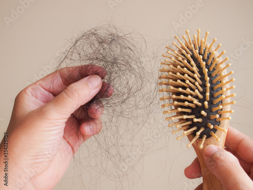 Hair loss problem concept.Woman pulling hair from comb.