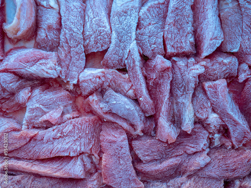 Slices of frozen beef meat thawed on a food tray