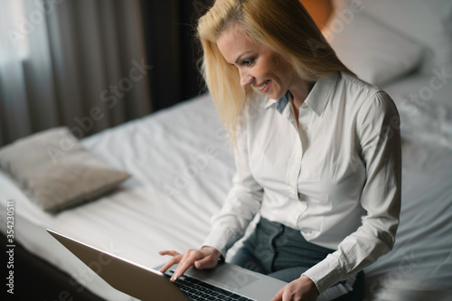 Young businesswoman working on lap top. Beautiful woman working in hotel room. 