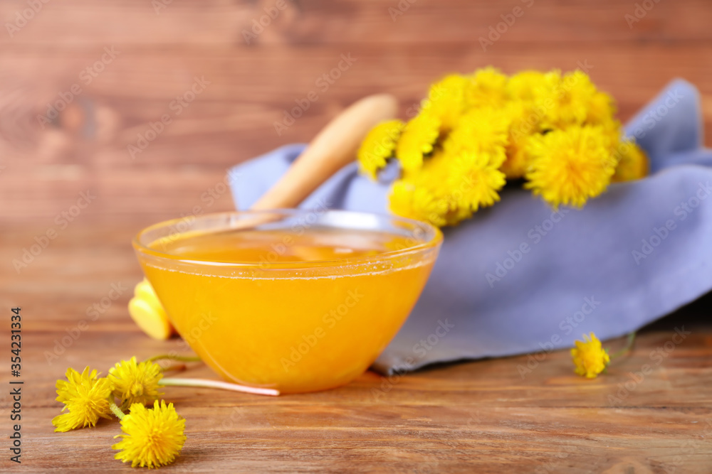 Bowl of sweet dandelion honey on wooden background Bowl of sweet dandelion honey on wooden background