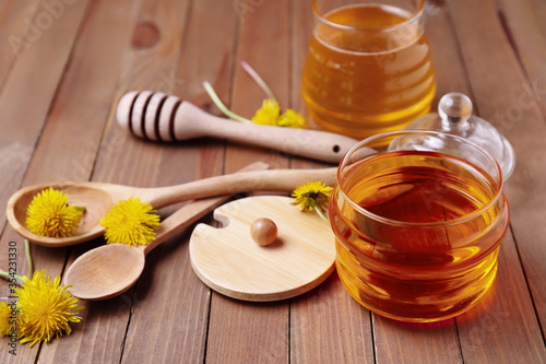 Composition with sweet dandelion honey on wooden background