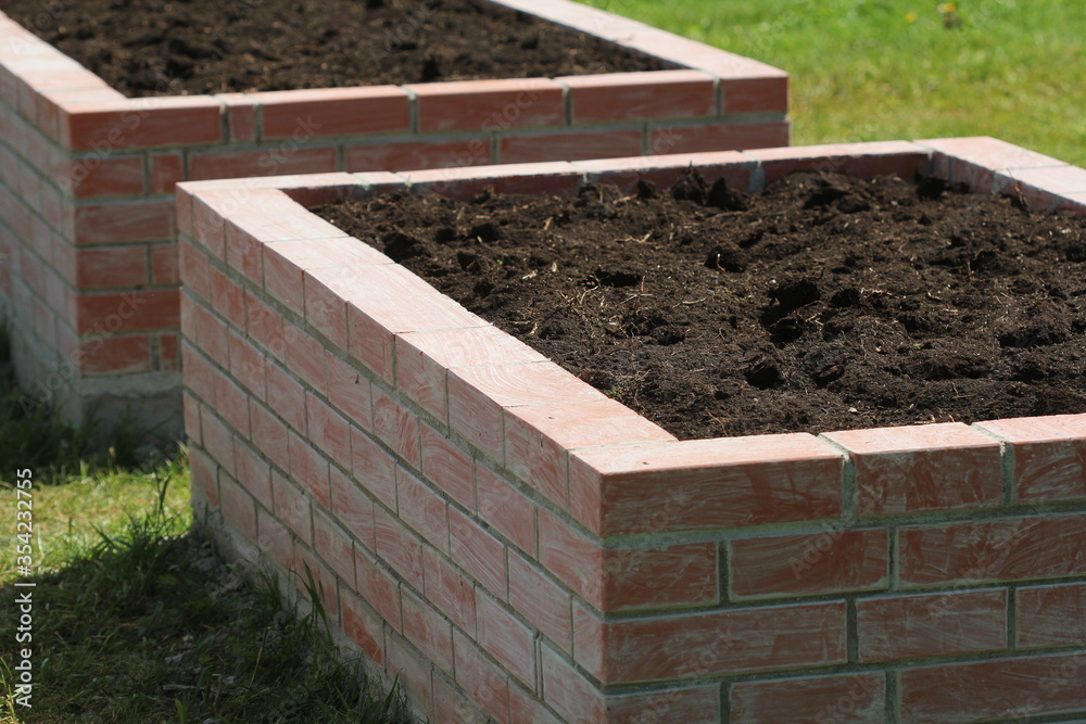 A modern vegetable garden with raised briks beds . Ready for planting A modern vegetable garden with raised briks beds . Ready for planting