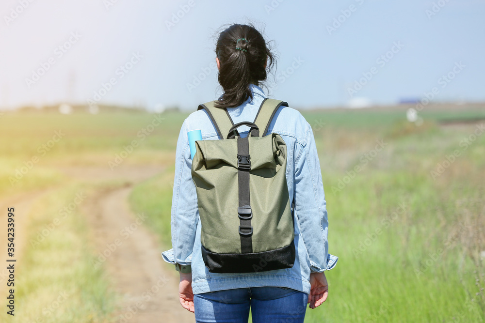 Female traveler with backpack in countryside Female traveler with backpack in countryside