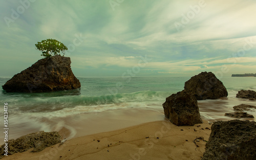 Beautiful seascape. Beach during daylight. Sandy beach with rocks. Waves captured with slow shutter speed. Soft focus. Bingin beach, Bali, Indonesia photo