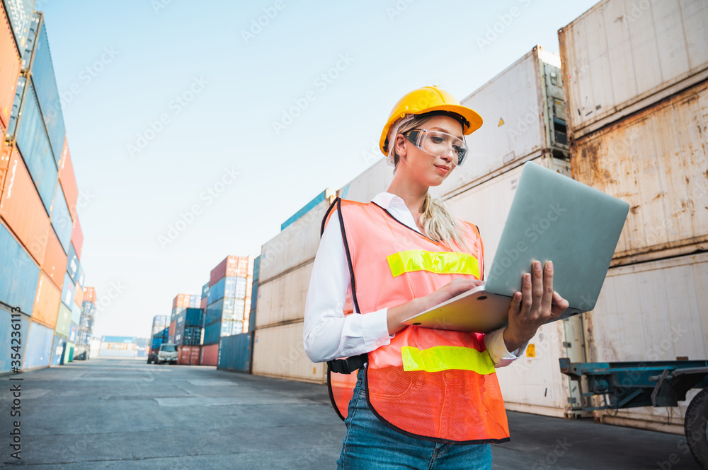 Foreman woman worker working checking at Container cargo harbor holding  laptop computer to loading containers. Dock female staff business Logistics  import export shipping concept. Photos | Adobe Stock