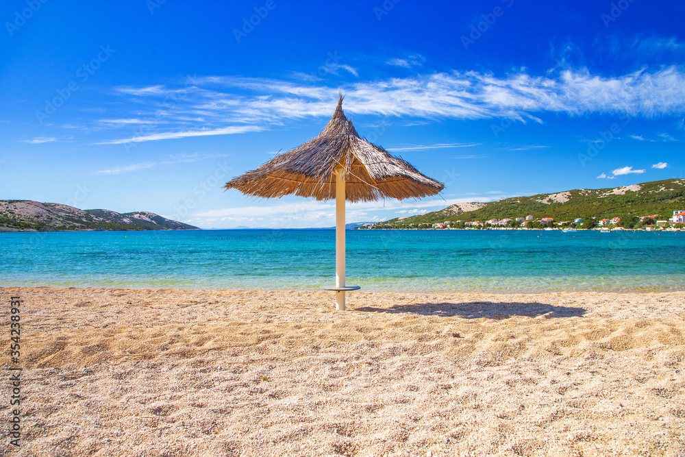 Adriatic sea shore in Croatia on Pag island, parasol on beautiful Puntica sand beach
