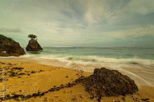 Beautiful seascape. Beach during daylight. Sandy beach with rocks. Waves captured with slow shutter speed. Soft focus. Bingin beach, Bali, Indonesia