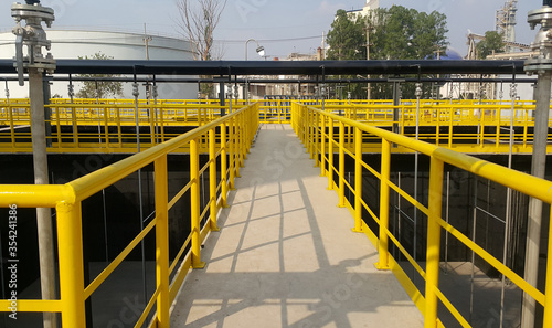 Fotografia Walk way with yellow handrail inside factory