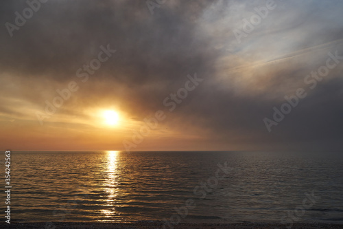 Sea sunset. Smoke wildfires sweeping across the sky.