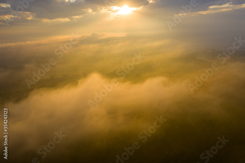 aerial view of Beautiful summer foggy nature landscape. Tranquil morning scene with foggy hollow and amazing clouds in sky during sunrise.Farm fields and green hills at sunrise.