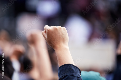 Hand in fist at a "black lives matter" rally in gathering, large group of protesters. © Mitch