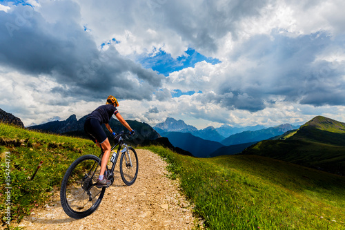 Cycling outdoor adventure in Dolomites. Cycling woman in Dolomites landscape. Woman cycling MTB enduro trail track. Outdoor sport activity.