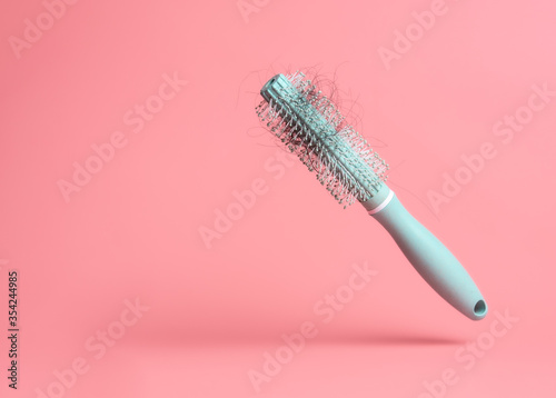 Konstfotografi Black hair loss problem with hairbrush on pink background