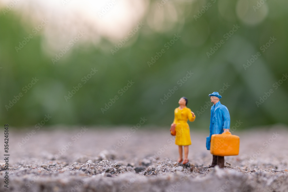Naklejka premium Miniature people , Traveler holding a handbag standing in the park