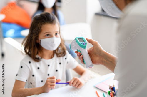 Teacher  child with face mask at school after covid-19 quarantine and lockdown.