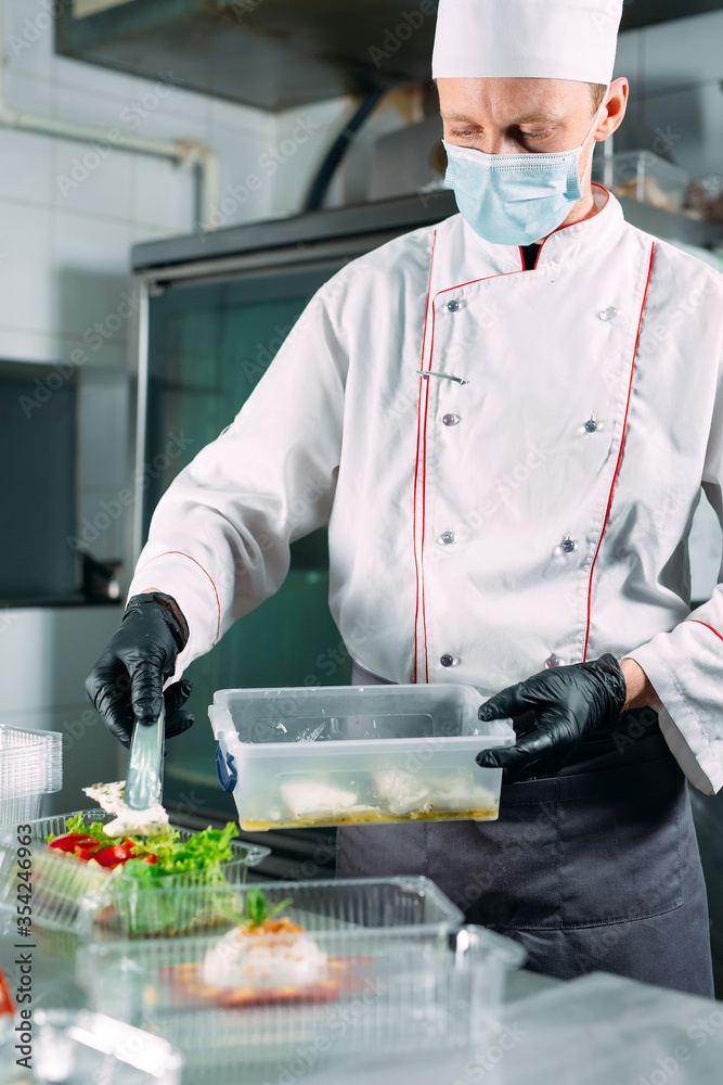 Food delivery in the restaurant. The chef prepares food in the restaurant and packs it in disposable dishes. Food delivery in the restaurant. The chef prepares food in the restaurant and packs it in disposable dishes.