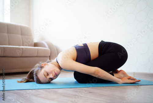yoga. beautiful girl is engaged in sports at home, making stretching. online workout.