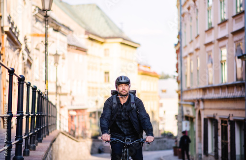 Front view of delivery man courier with bicycle cycling in town. © Halfpoint