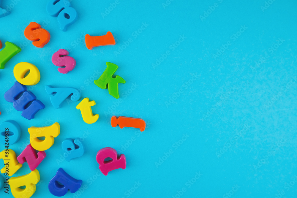 Naklejka premium Plastic colourful alphabet letters on the blue background.