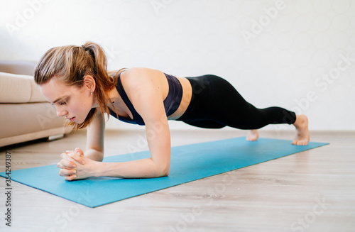 girl is engaged in sports at home online workouts. fitness exercise -  plank