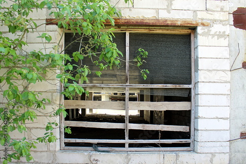 Fotografie View of an abandoned construction site through a large window boarded up with bo