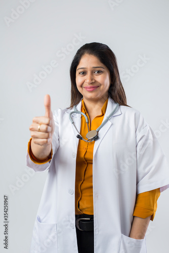 Photography Young Indian female doctor showing hand sign.
