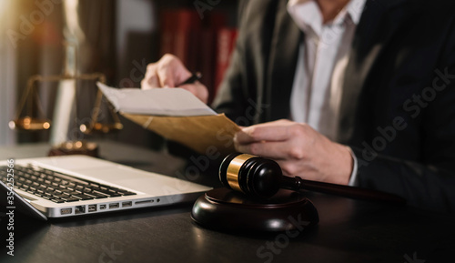 Lawyer office. gavel of Justice with scales and lawyer working on a documents in courtroom.