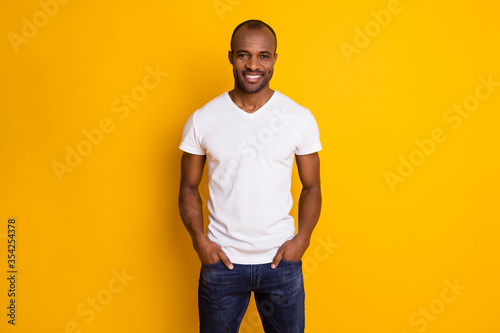 Portrait of attractive afro american guy enjoy spring free time weekend put hands pocket wear modern hipster clothes isolated over vivid color background