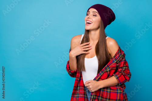 Photo of amazing stylish lady glad warm spring autumn weather street look eyes closed laughing out loud hand on chest wear casual hat plaid shirt isolated blue color background