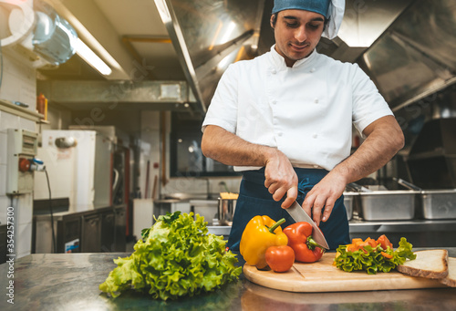 Male chef preparing a salad in the kitchen of a restaurant