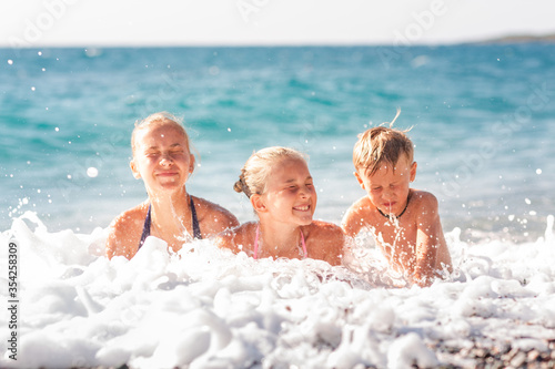 Happy kids on the beach having fun © len44ik