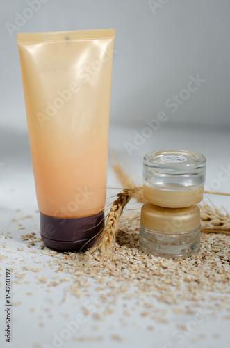 jars for cosmetics on a white background with wheat and oatmeal