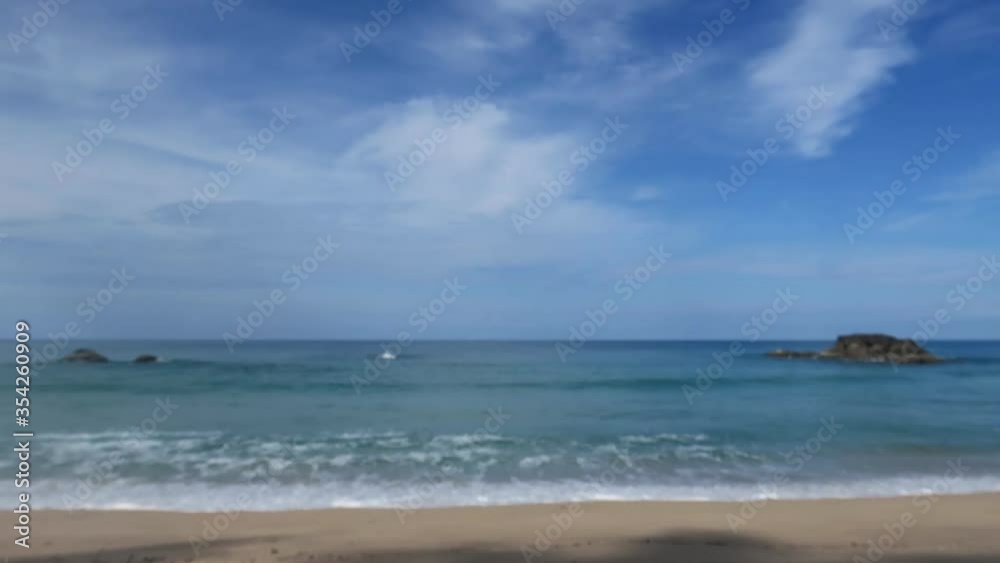 Calm sea water surface & calming white ocean waves touching exotic golden sand beach on beautiful sunny blue sky with white clouds & puffy fluffy cloudscape in tropical summer sunlight, Slow motion Calm sea water surface & calming white ocean waves touching exotic golden sand beach on beautiful sunny blue sky with white clouds & puffy fluffy cloudscape in tropical summer sunlight, Slow motion