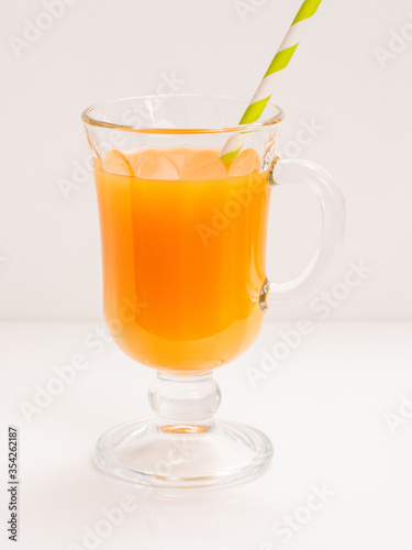 Glass of fresh orange juice on a white background.