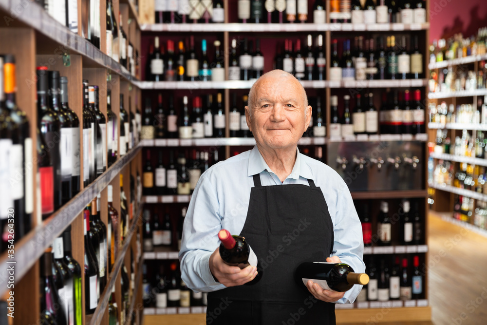 Senior male vintner giving recommendation about purchase wine in his wine house