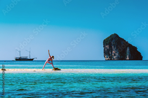 Unrecognisable woman in yoga pose on the beach on an island in Thailand