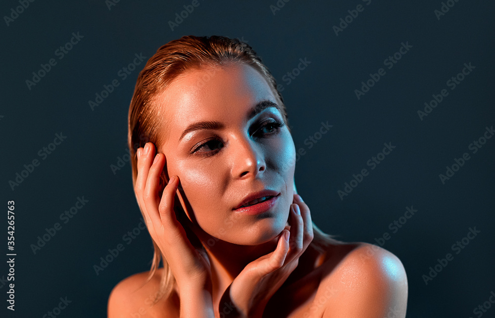 Fototapeta premium Blonde girl with perfect skin on a gray background.