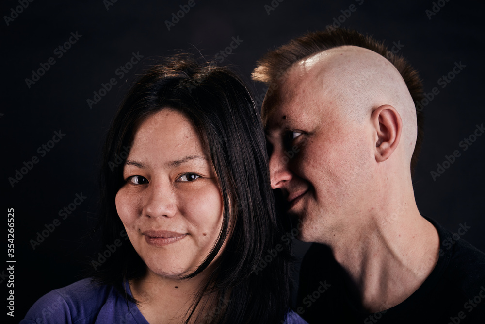 Portrait of mixed race couple in the studio. Two people together hug.