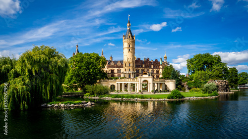 lake view of the popular schwerin castle the seat of the regional government office in mecklenburg western pomerania in front of blue sky with nice cloudscape at daytime on a lovely summer day photo