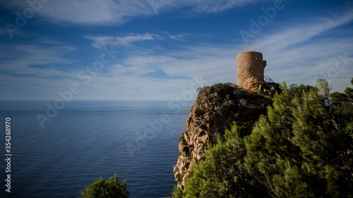 ancient watchtower torre des verger at the steep seacoast of northwest mallorca nearby banyalbufar with view to the horizon of the mediterranean sea