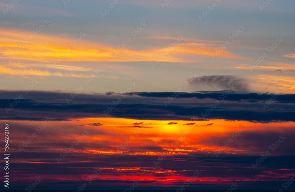 Vibrant cloudy sunset over dark blue ocean