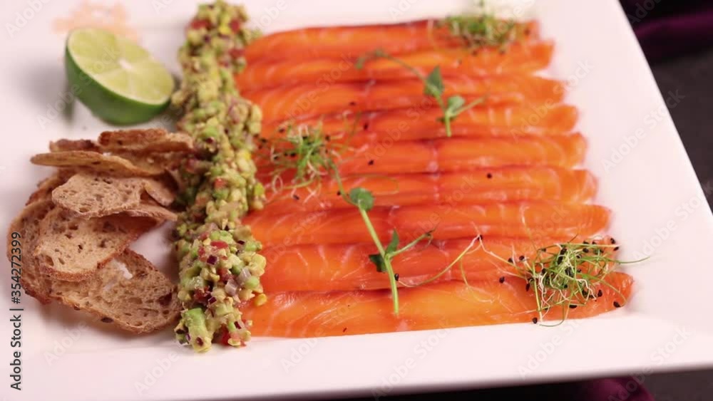 Salmon carpaccio with croutons and lime. On a white plate Salmon carpaccio with croutons and lime. On a white plate