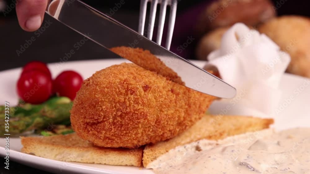 Kyiv cutlet with croutons, tomatoes, asparagus on a white plate