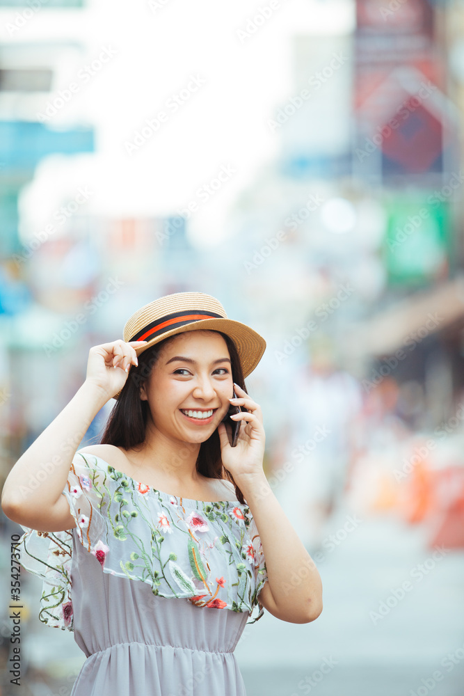 Young beautiful woman smiling happy walking on city streets on a sunny day of summer talking with smartphone