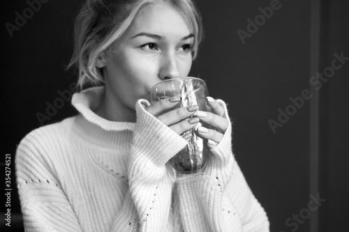 woman drinking hot tea while sitting at a table in a restaurant