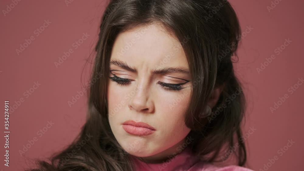 Young sad pretty woman isolated over pink wall background Young sad pretty woman isolated over pink wall background