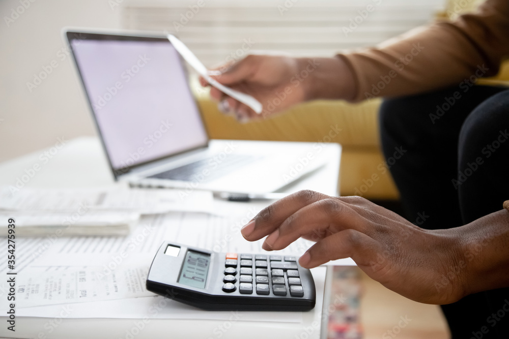 Manage planning family budget, savings and payment concept. Close up image hands of African man using calculator calculates finances checking family expenses, do small business, month result analysis Manage planning family budget, savings and payment concept. Close up image hands of African man using calculator calculates finances checking family expenses, do small business, month result analysis
