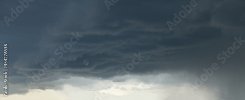 dark rainy storm cloud sky with clearance near horizon