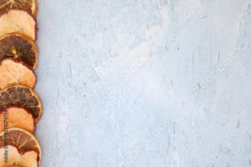 slices of orange and apple shot on a blue contrast colour textured background, space for text